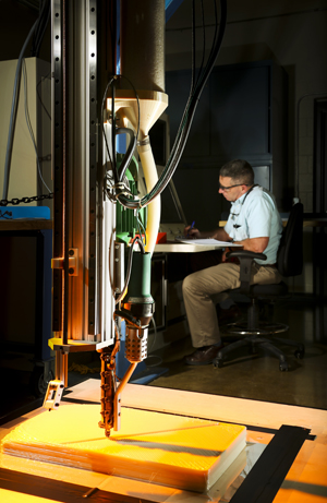 A new partnership between Local Motors and ORNL will explore vehicle design and construction using 3-D printing technologies. The project will make use of equipment at DOE's Manufacturing Demonstration Facility, such as the large-scale additive manufacturing machine operated here by ORNL's Peter Lloyd.
