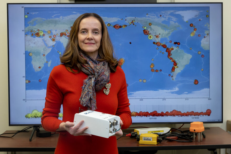 An employee at ORNL stands in front of a global map