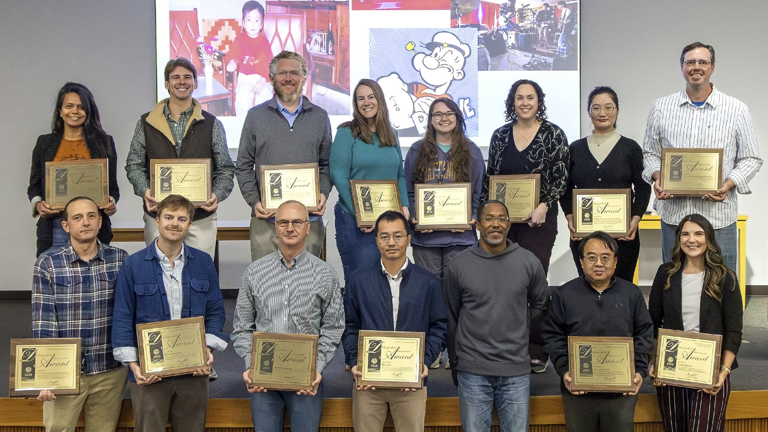 group of award winners holding plaques
