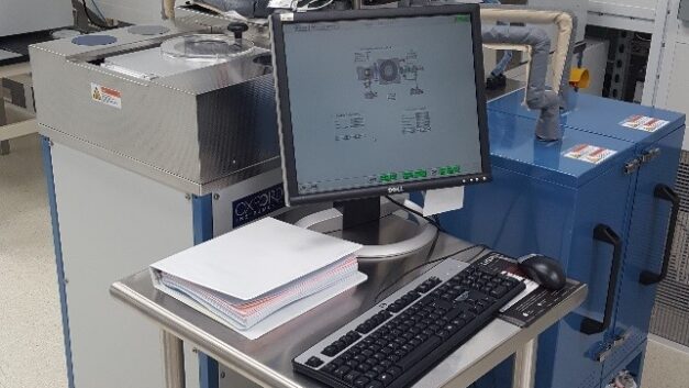 A group of short cabinat-like equipment pieces clustered around a desk with a computer
