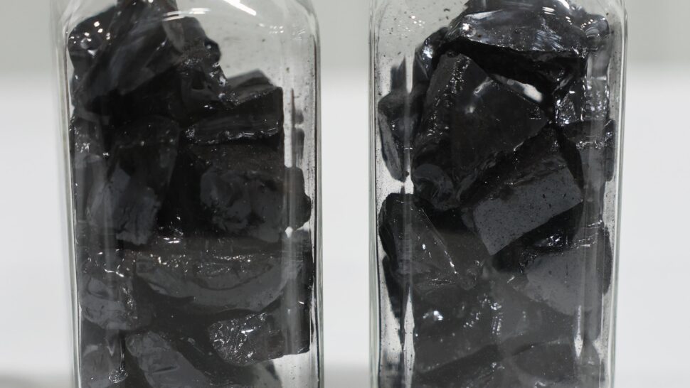 Pieces of carbon precursor are displayed inside of two bottles.