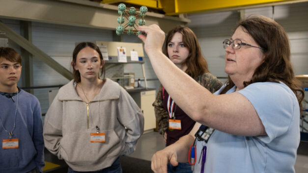 SNS scientific associate Melanie Kirkham shows Sophia and other Robertsville Middle School students a model of an atomic structure during their visit to the Spallation Neutron Source. Credit: Cindi Zdrinc/ORNL, U.S. Dept. of Energy