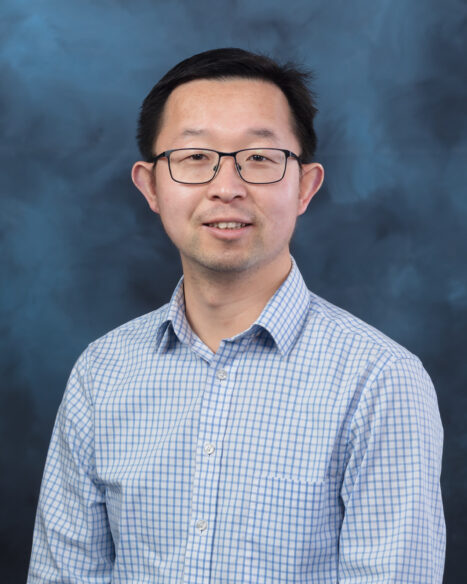 Portrait of Kai Li, R&D staff member at Oak Ridge National Laboratory, standing against a studio backdrop.