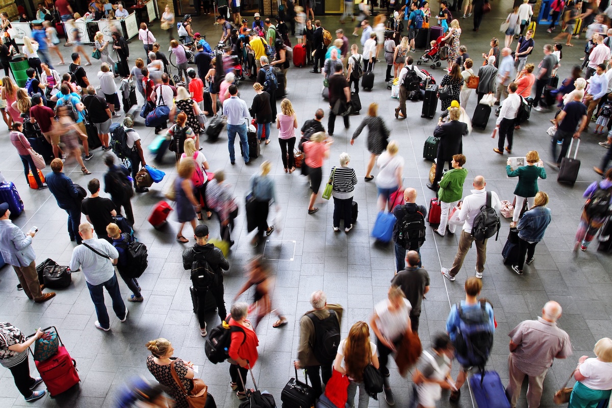The concourse of King's Cross train station in London during the peak time rush hour and crowded with passengers, commuters and travellers waiting patiently for information about their trains. Image from Envato
