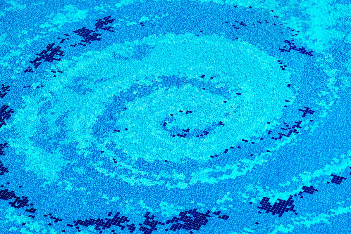 Abstract image features a swirling spiral pattern rendered in shades of blue mosaic. Image from Envato