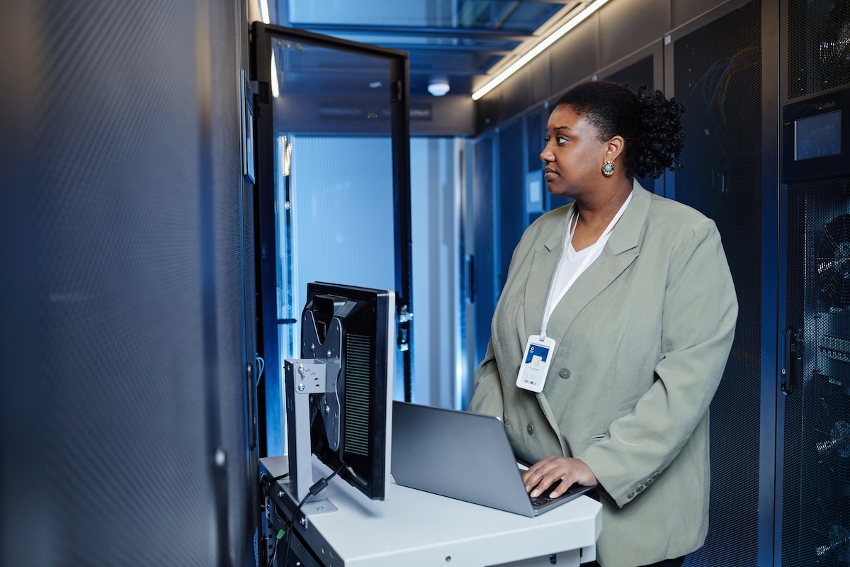 Side view portrait of African American young woman using laptop. Image from Envato