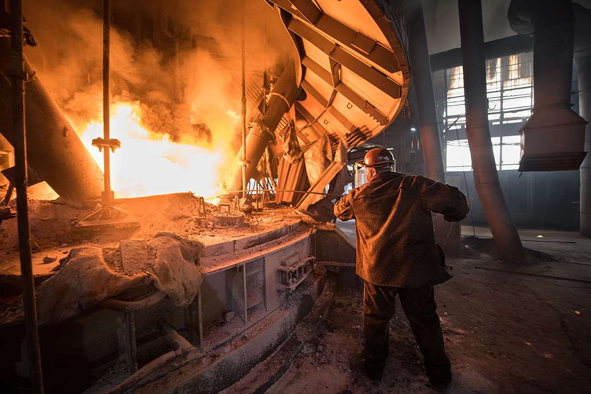 Steelworker at work near the arc furnace. Envato