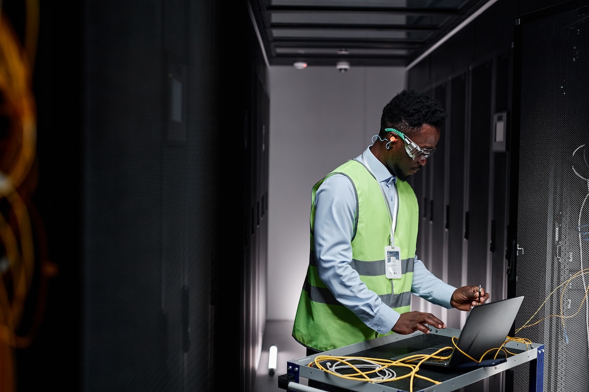 Graphic side view portrait of young network technician repairing servers in data center. Image from Envato