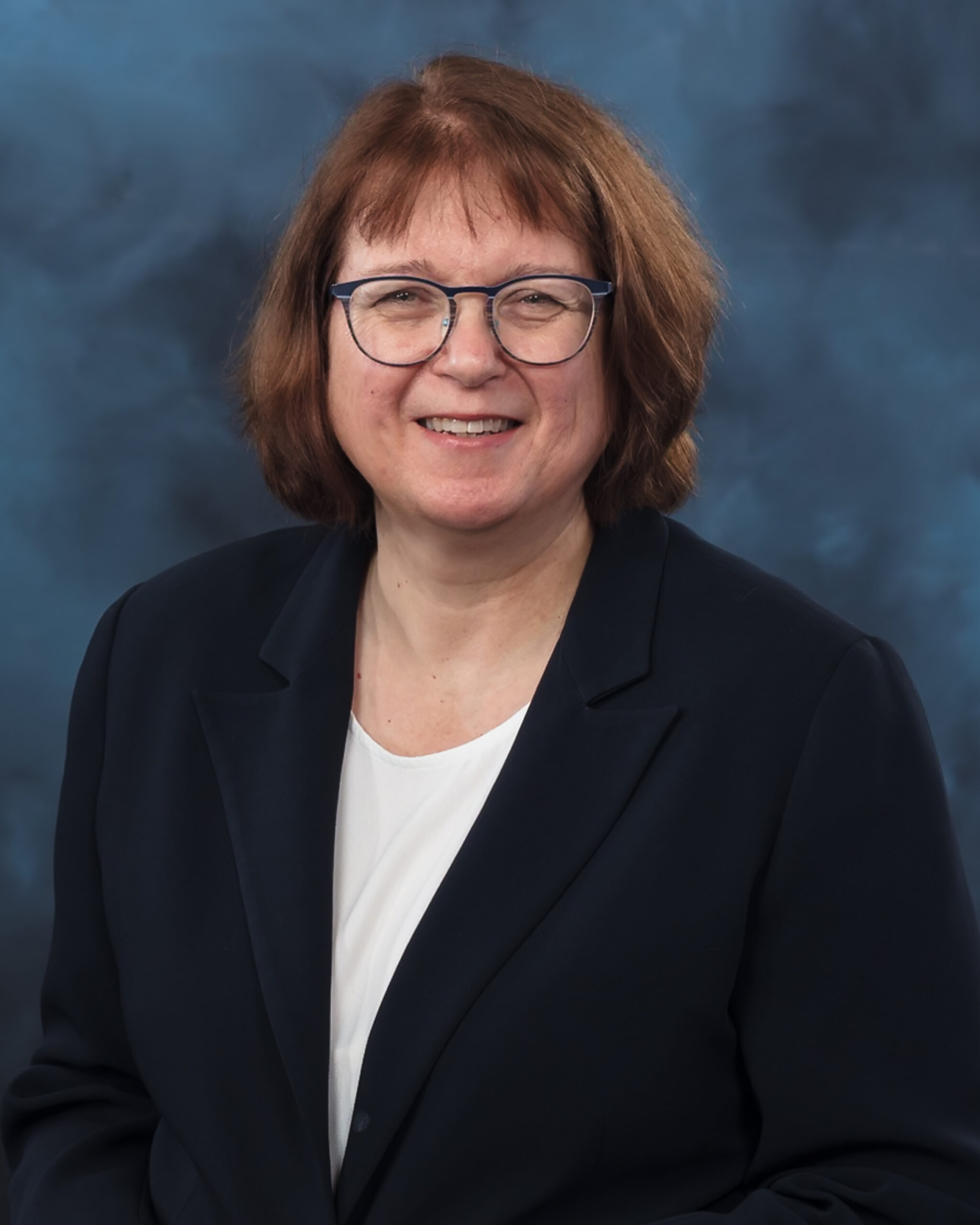 A woman with a black suit and glasses