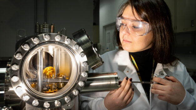 A woman inserting a sample into a metal machine