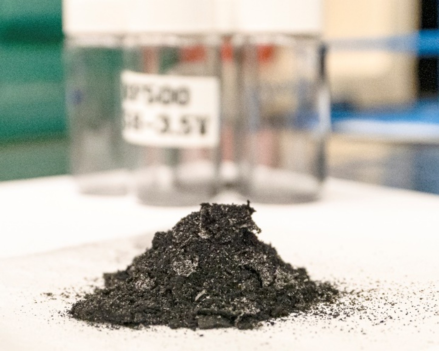 A small pile of dark, crushed material sits on a laboratory surface.
